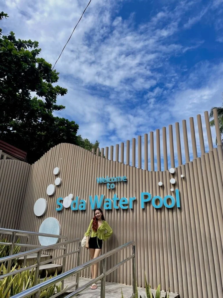 Beautiful woman posing by the Bura Soda Water Pool logo