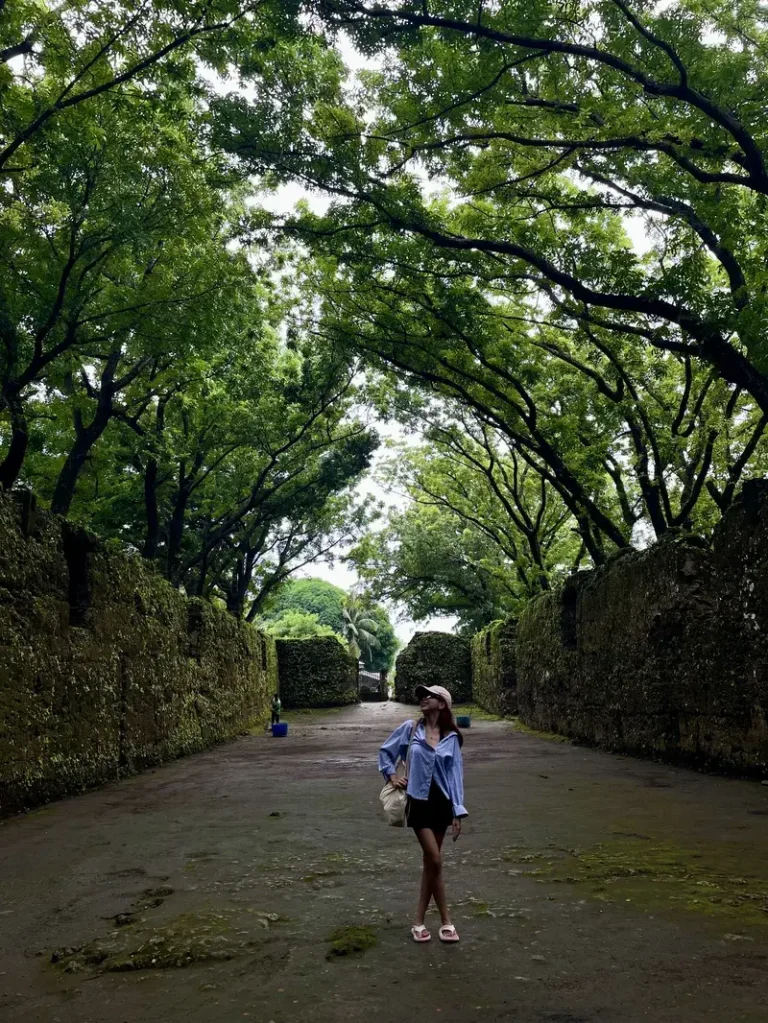 Girlfriend with a pink hat looking up at the trees of Old Gui-ob church ruins
