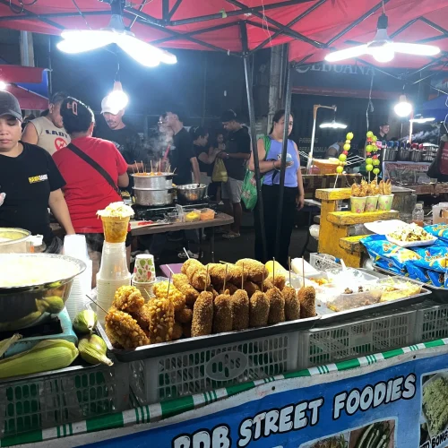 Corndogs and corn on the cob being sold at Colon Night Market